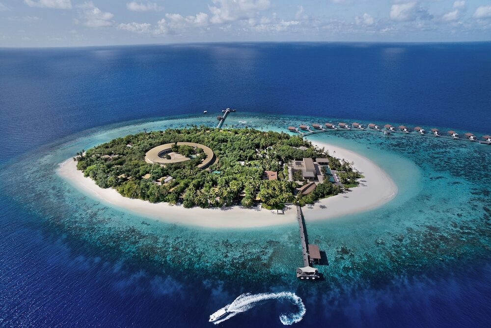 Aerial view of island and overwater bungalows at Park Hyatt Maldives