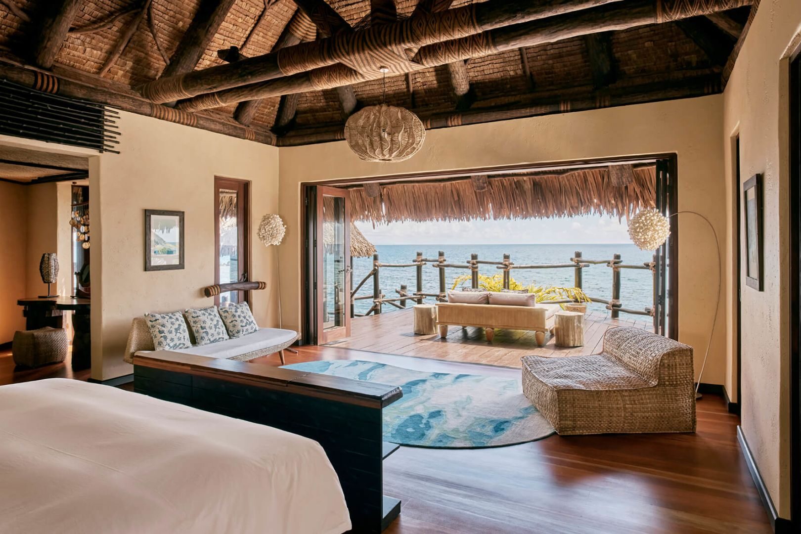 Main living space opening up onto a terrace in an overwater bungalow at COMO Laucala