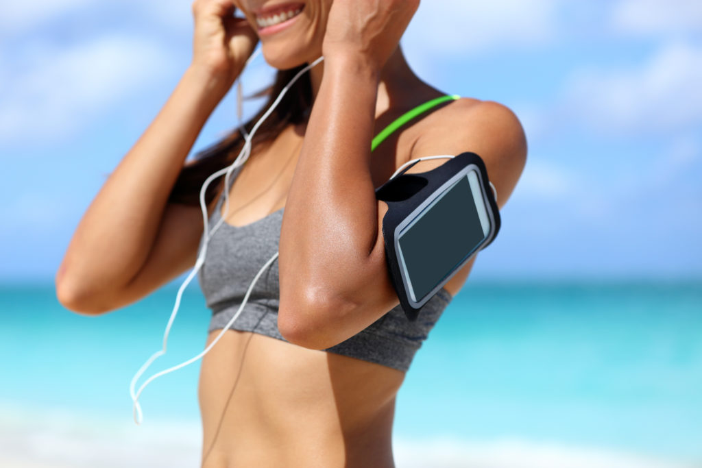 Women wearing a smartphone fitness arm band on beach