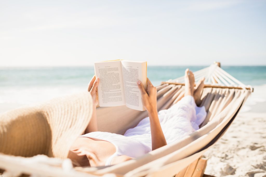 Woman reading book in hammock