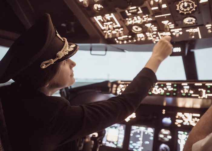 Pilot switching controls in cockpit of airplane