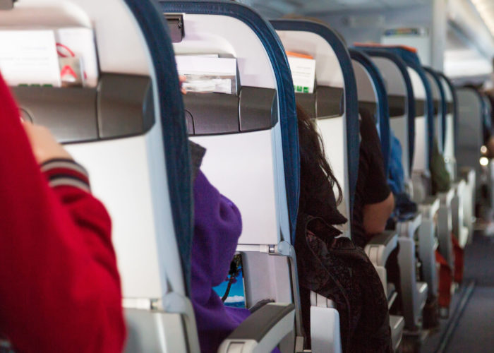 View down the center aisle of a plane as people board