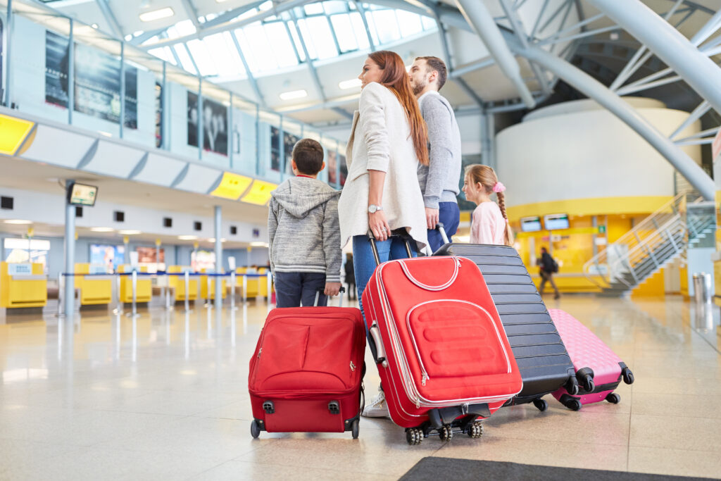 Family arriving at airport with their rolling luggage