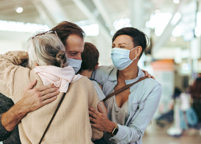 Elderly person greeting family at airport