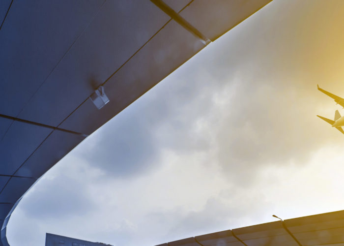 Plane flying over the passenger drop off area of an airport