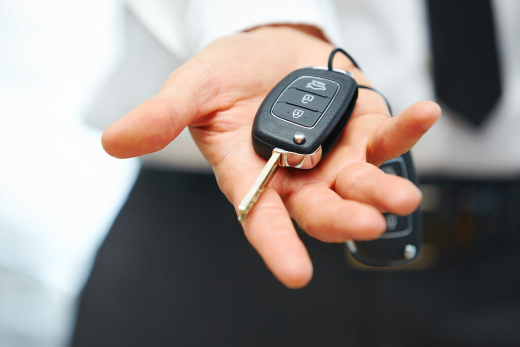 Person holding out a set of car keys to the camera