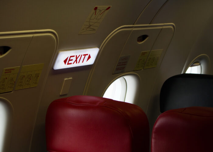 Close up of exit sign in exit row of plane