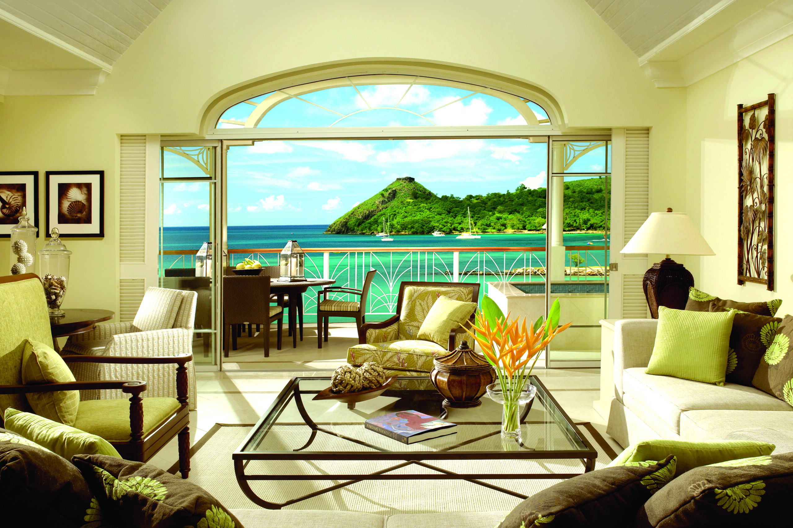 Living area of a suite at The Landings Saint Lucia, with large balcony doors open to the ocean view