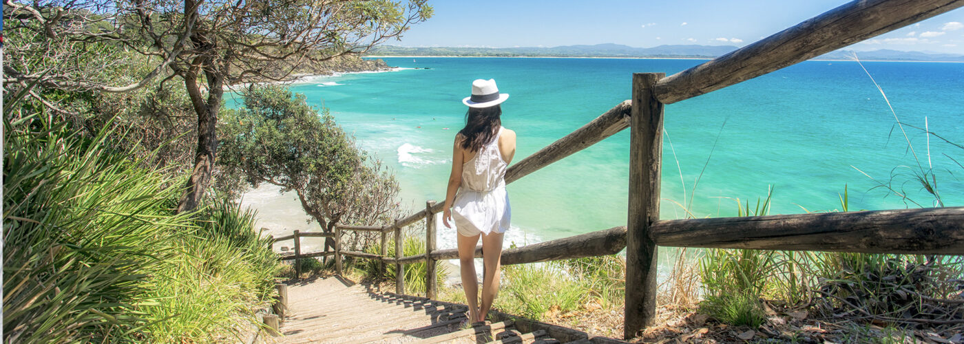 woman wlaking down steps to the beach