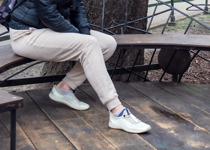 Woman sitting on a park bench in sweatpants