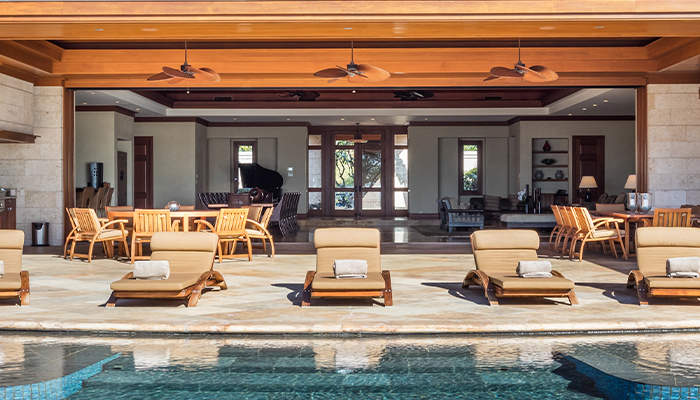 Lounge chairs by a pool at a rental property provided by Homes & Villas by Marriott Bonvoy