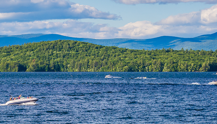 Boats on Lake Winni with the mountains in the background during the summer.